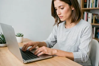 Femme tapant sur un clavier d'ordinateur portable pour insérer un arobase et des caractères spéciaux
